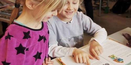 To piger læser i Den første læsning